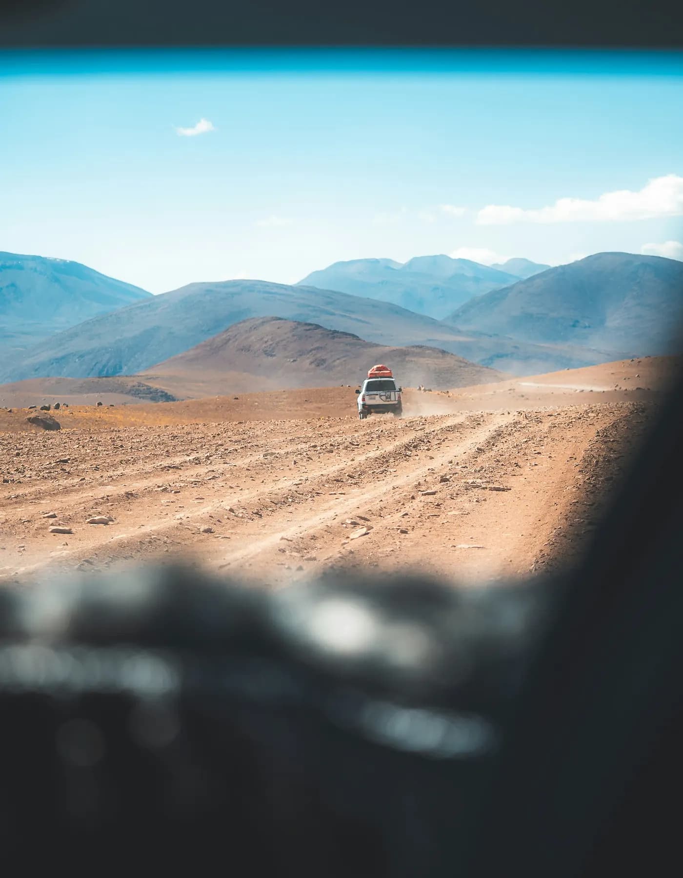 Carro em estrada de terra no deserto ao amanhecer