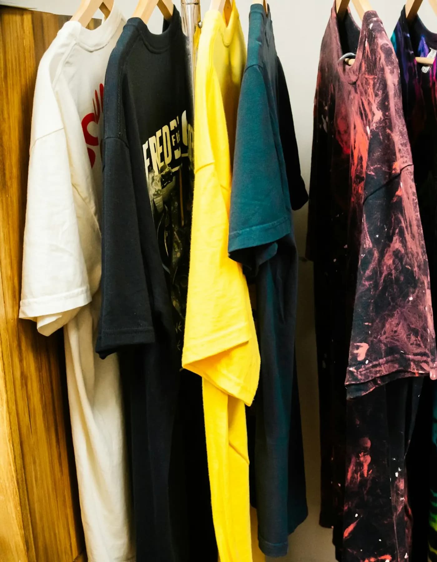 Camisetas penduradas em arara de loja